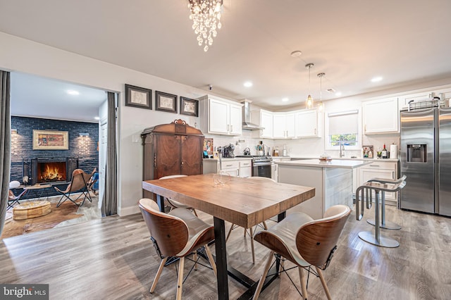 dining space featuring a fireplace and light wood-type flooring