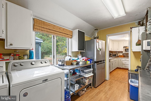 washroom with washer and clothes dryer, light wood-type flooring, a textured ceiling, and ornamental molding