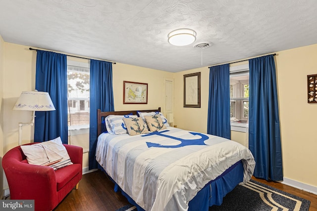 bedroom featuring dark hardwood / wood-style floors and a textured ceiling