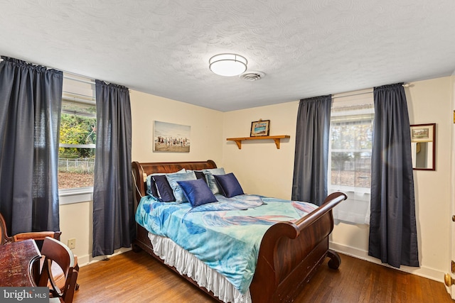 bedroom with hardwood / wood-style floors and a textured ceiling