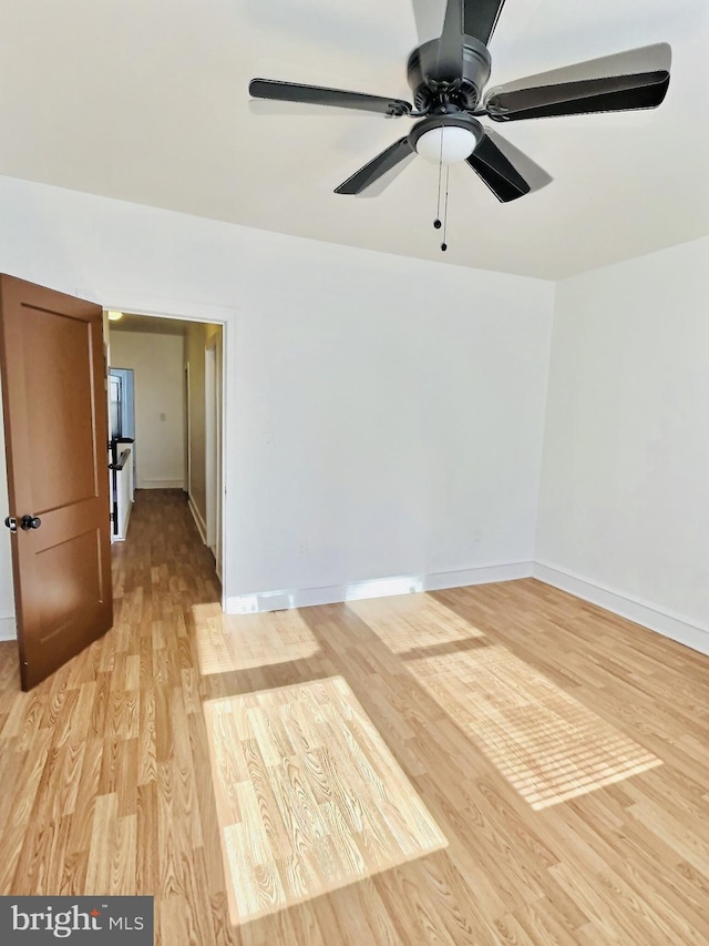 empty room with light hardwood / wood-style floors and ceiling fan