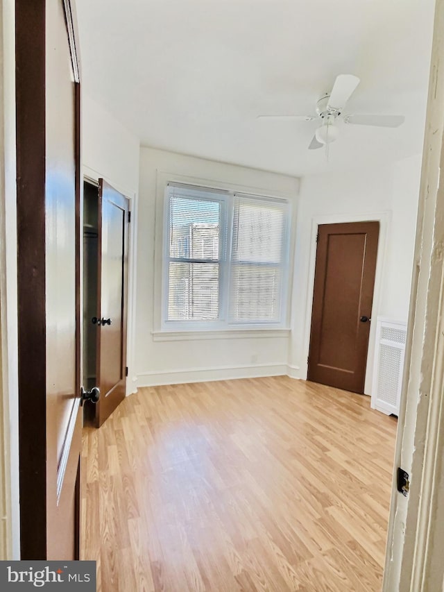 spare room with radiator, ceiling fan, and light hardwood / wood-style flooring