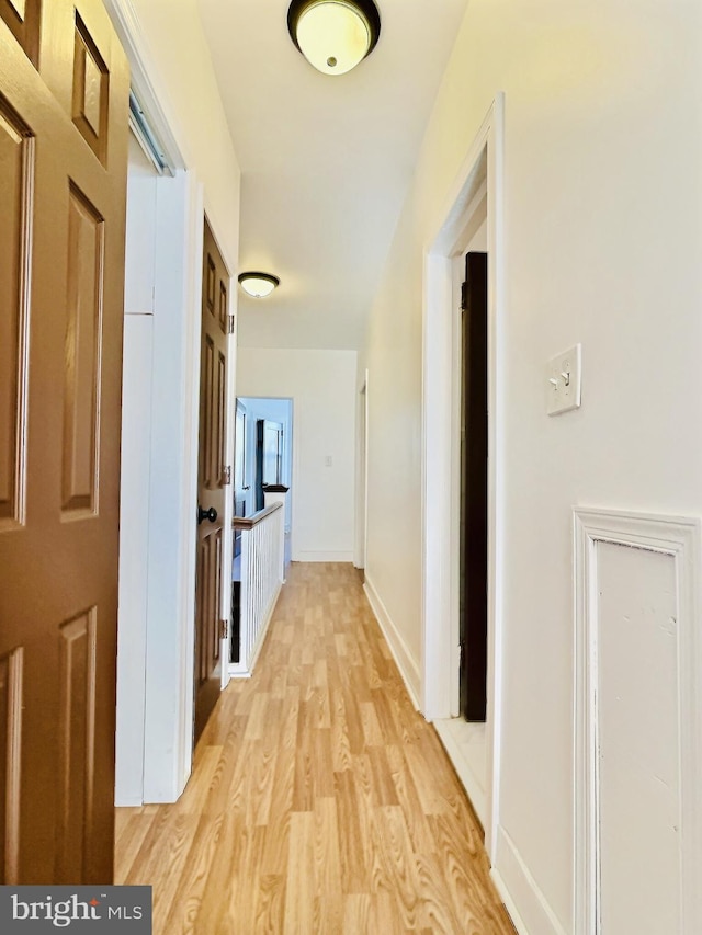 hallway with light hardwood / wood-style floors