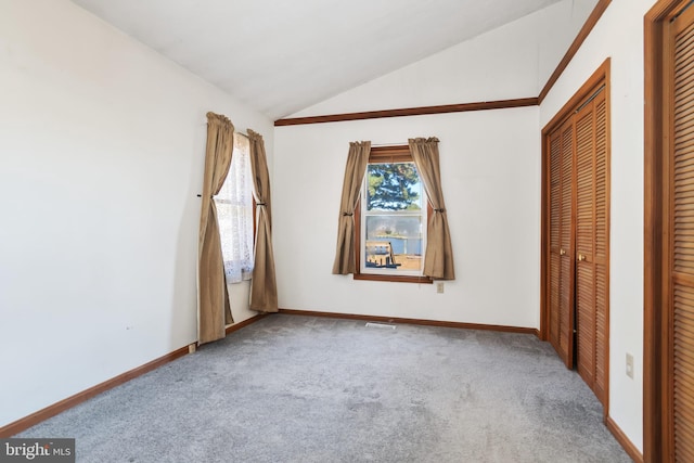 unfurnished bedroom with lofted ceiling, light carpet, and a closet