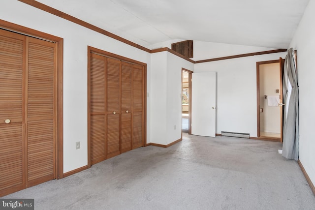 unfurnished bedroom with light carpet, multiple closets, baseboard heating, and vaulted ceiling