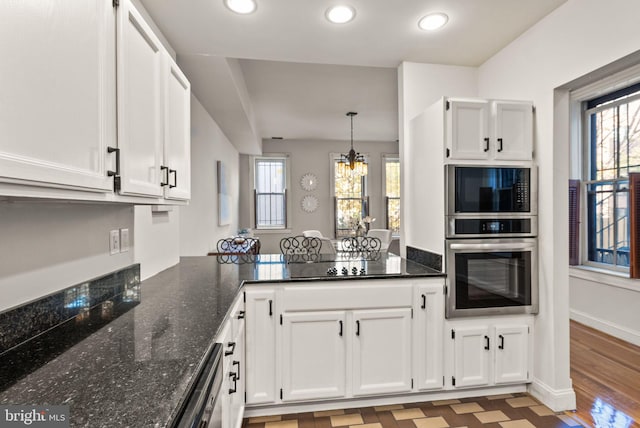 kitchen with white cabinets, dark stone counters, light hardwood / wood-style floors, and oven