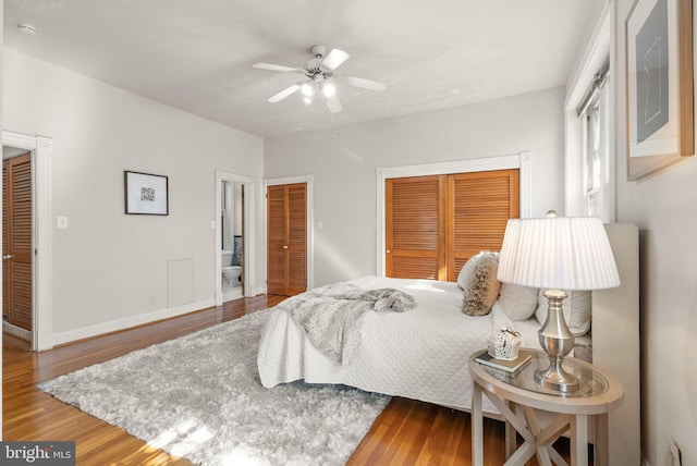 bedroom with multiple closets, wood-type flooring, and ceiling fan