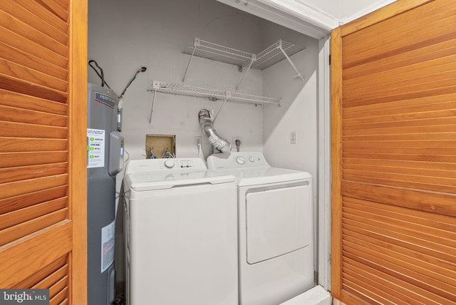 laundry room featuring electric water heater and separate washer and dryer