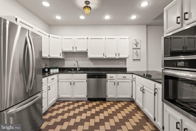 kitchen with appliances with stainless steel finishes, white cabinets, and sink