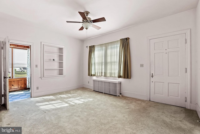 carpeted entryway with radiator heating unit and ceiling fan