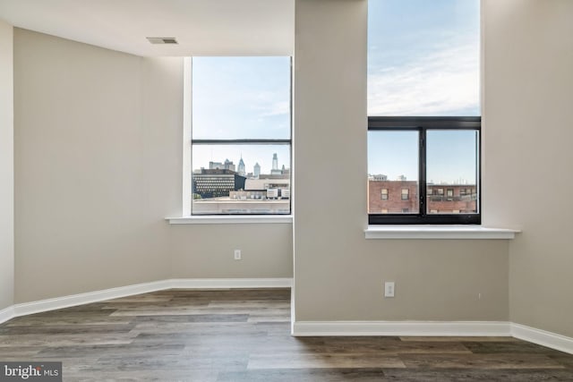 unfurnished room with dark wood-type flooring and a healthy amount of sunlight