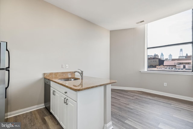 kitchen with white cabinets, hardwood / wood-style flooring, sink, and appliances with stainless steel finishes