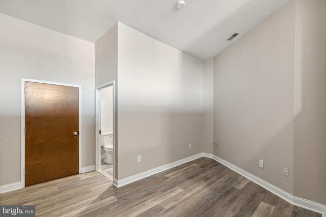 unfurnished room featuring hardwood / wood-style flooring and vaulted ceiling