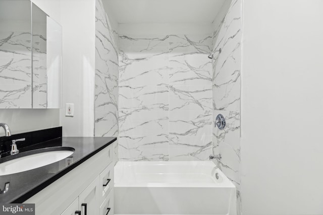 bathroom with tiled shower / bath and vanity