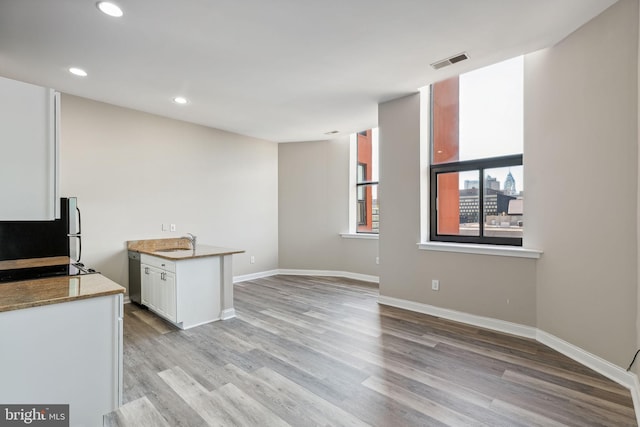 kitchen with refrigerator, white cabinetry, sink, and light hardwood / wood-style floors