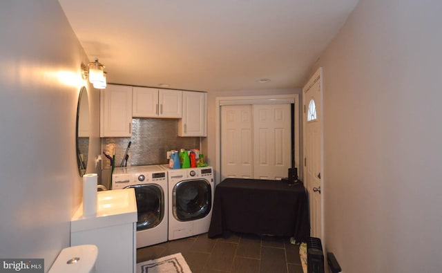 washroom featuring separate washer and dryer and dark tile patterned flooring