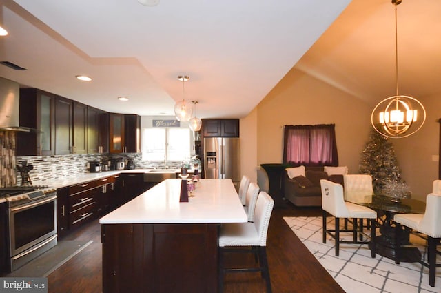 kitchen with stainless steel appliances, light hardwood / wood-style floors, pendant lighting, and a kitchen island