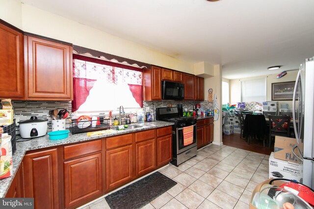 kitchen with sink, decorative backsplash, stainless steel appliances, and light tile patterned floors