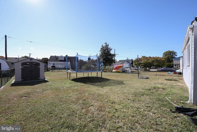 view of yard featuring a storage unit and a trampoline