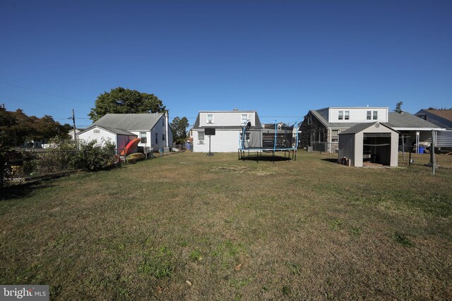 view of yard featuring a storage shed and a trampoline