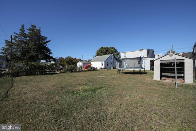 view of yard featuring a storage unit and a trampoline