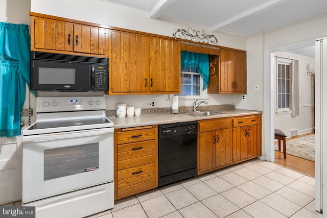 kitchen with sink, black appliances, and light hardwood / wood-style flooring