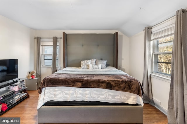 bedroom with hardwood / wood-style flooring and vaulted ceiling