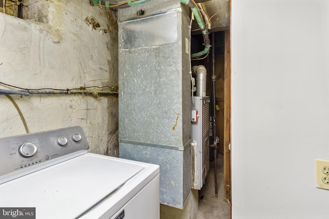 laundry room featuring heating unit and washer / dryer