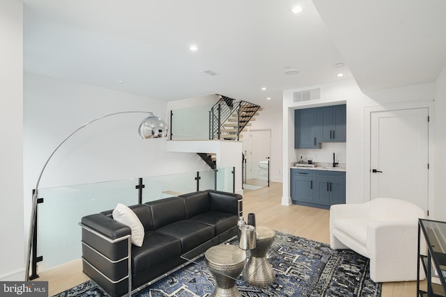 living room with light hardwood / wood-style floors and sink