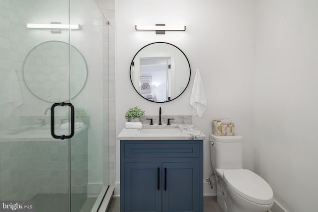 bathroom with vanity, toilet, and a shower with shower door