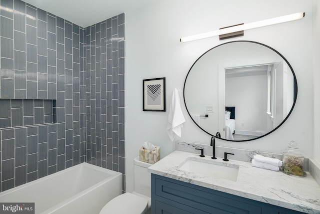 full bathroom with tiled shower / bath, vanity, and toilet