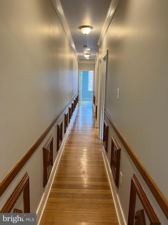 hallway featuring ornamental molding and light wood-type flooring