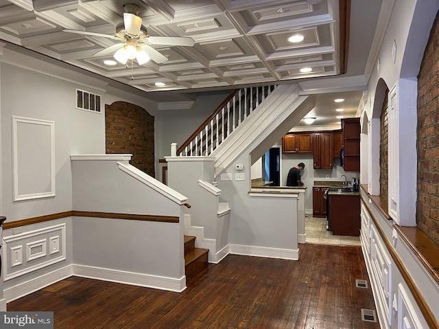 stairs featuring ceiling fan, hardwood / wood-style flooring, ornamental molding, beamed ceiling, and coffered ceiling