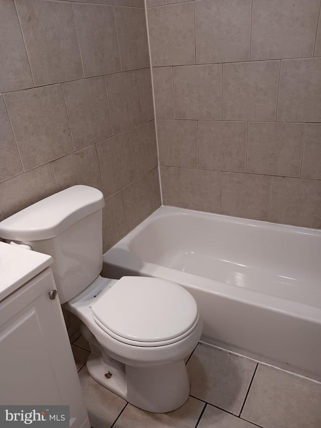 bathroom featuring tile walls, vanity, toilet, and tile patterned flooring