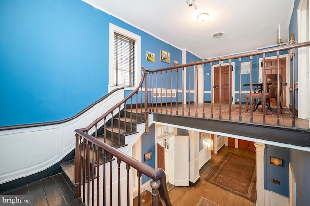 stairway featuring ornamental molding and hardwood / wood-style flooring