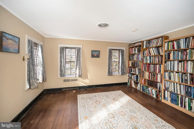 living area featuring a wealth of natural light, ornamental molding, and dark wood-type flooring