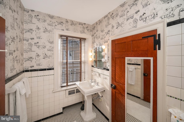 bathroom with tile patterned floors, tile walls, and plenty of natural light