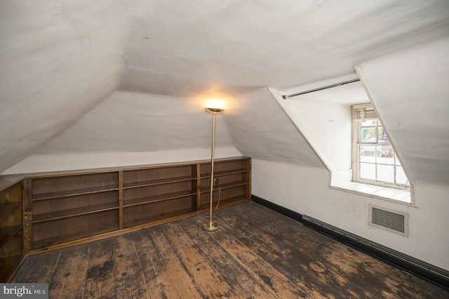 additional living space with vaulted ceiling and dark hardwood / wood-style floors