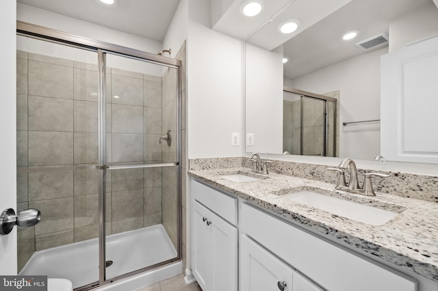 bathroom featuring walk in shower, vanity, and tile patterned floors