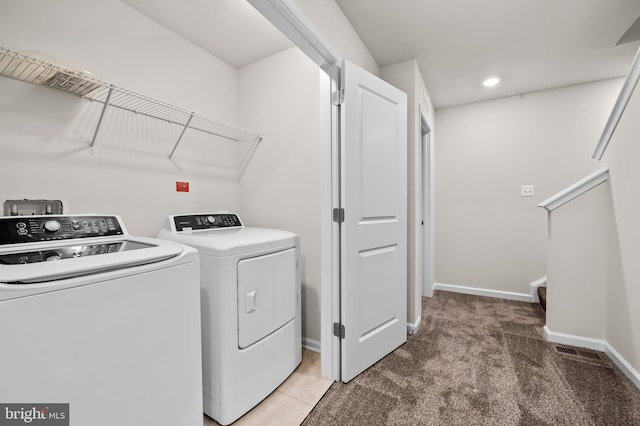 clothes washing area with separate washer and dryer and carpet floors