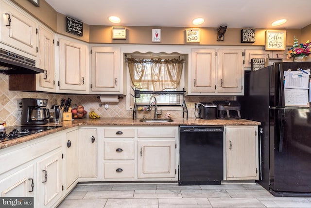 kitchen with stone counters, decorative backsplash, sink, and black appliances