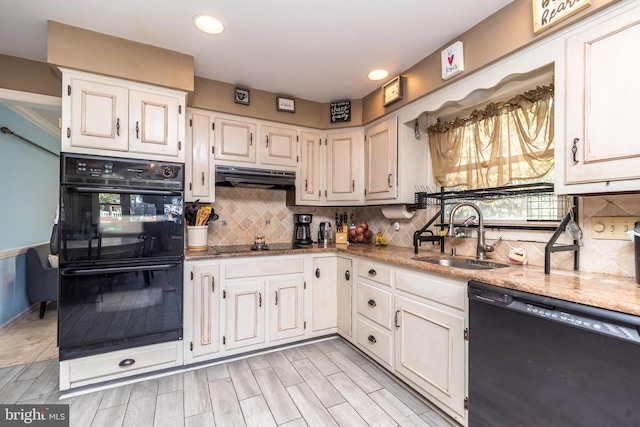 kitchen featuring sink, light stone counters, backsplash, black appliances, and light wood-type flooring