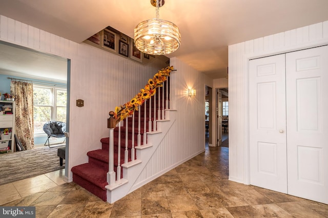 stairway with a notable chandelier