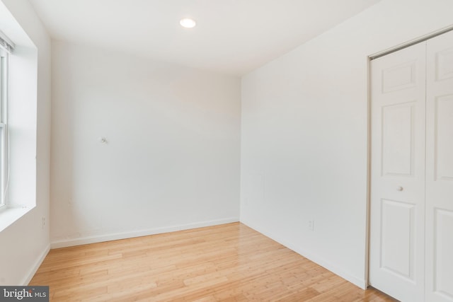 spare room with a healthy amount of sunlight and hardwood / wood-style floors