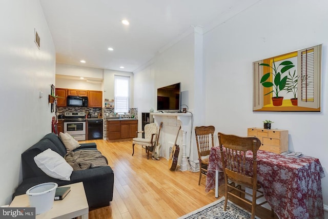 living room with light hardwood / wood-style flooring and ornamental molding