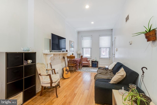 living room with light hardwood / wood-style floors and ornamental molding