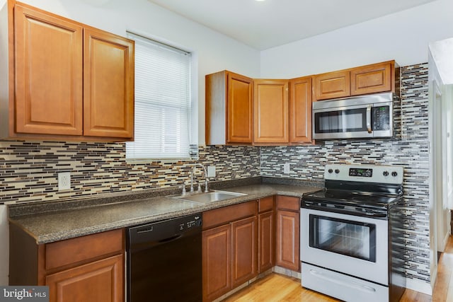 kitchen with tasteful backsplash, black dishwasher, electric range, light hardwood / wood-style flooring, and sink