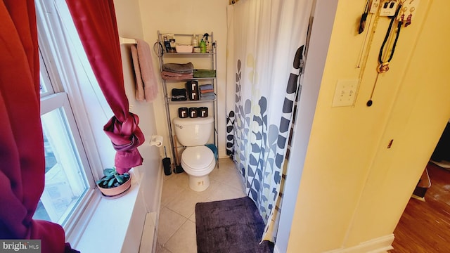 bathroom with walk in shower, tile patterned flooring, and toilet