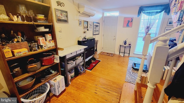 hallway featuring an AC wall unit and hardwood / wood-style flooring