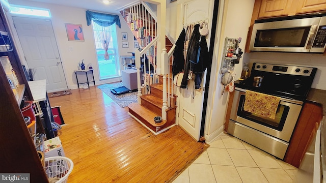 kitchen with appliances with stainless steel finishes and light hardwood / wood-style floors